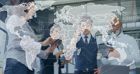 Standing four colleagues in business attire reviewing two tablets, smartphone and laptop in office. Collaboration, teamwork, innovation, technology, startup, corporate, executiveの写真素材