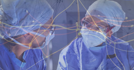 Collaborating surgeons wearing scrubs, masks and goggles in OR, monitors displaying overlay....