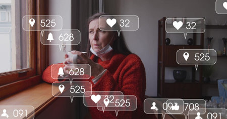 Gazing woman in red sweater, mask, holding white mug by home window, floating icons, copy space....