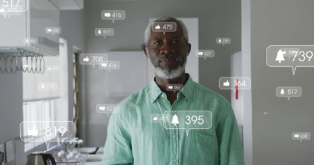 Standing mature African American man monitoring floating notifications in kitchen, with kettle, mug. Lifestyle, domestic, modern, contemporary, technology, communication, eleganceの写真素材