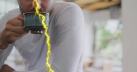 White man lifting ceramic mug and drinking hot beverage in cafe, with yellow lightning bolt overlay....