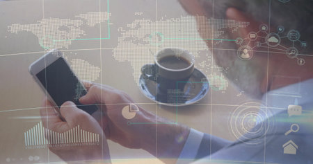 Holding smartphone senior executive analyzing data at wooden desk, with coffee and digital graphics....