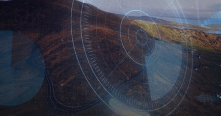 Rugged hillside descending coastal bay, showing winding road and HUD overlay with circles and lines....