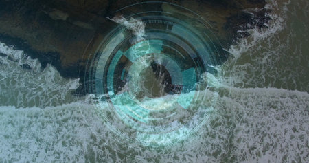 Displaying waves rolling along rocky shoreline in aerial view, with concentric circular HUD overlay. Ocean, coastline, digital interface, hud, radar, surveillance, maritimeの写真素材