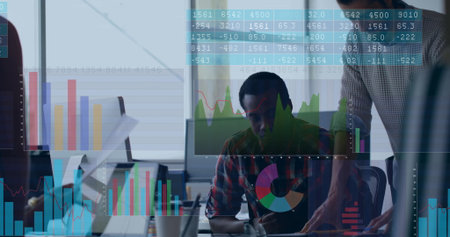 Pointing man in sweater guiding coworker in plaid at office desk with monitor, floating data charts....