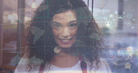 Examining world map and chart overlays through clear glass panel by Hispanic woman in modern office....