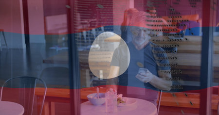 Sitting mature man eating meal at coffee shop behind perforated glass, with bowl and water bottle....