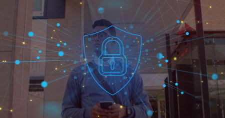 Holding smartphone man in sweater at office entry showing blue shield with padlock network overlay....