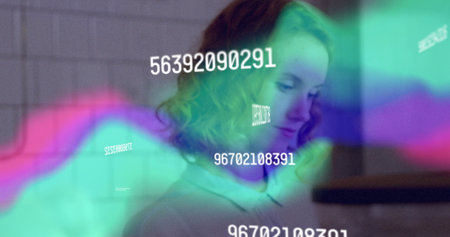Curly-haired woman in collared shirt viewing data at workstation, with colored waveforms and codes....