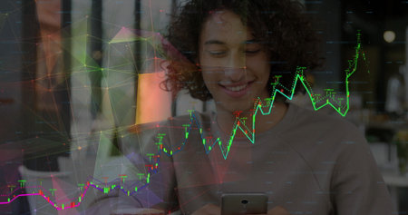 Smiling man with curls analyzing financial chart overlay at table in coffee shop, with smartphone....