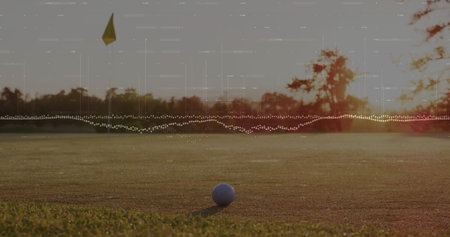 White golf ball sitting on putting green at sunset, with yellow flag hole, audio waveform overlay. Sports, leisure, outdoor, minimalism, relaxation, nature, recreationの写真素材