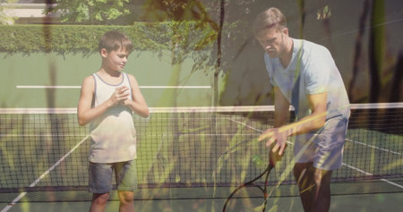 Father and son practicing tennis on backyard court with racket balancing balls on net over lines....