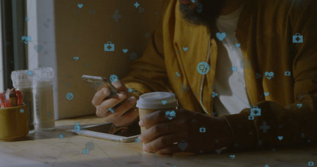 Bearded man holding smartphone and coffee cup at coffee shop table, with health icons, copy space....