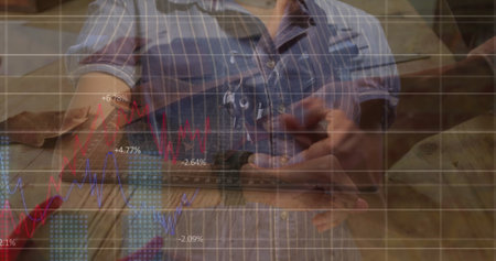 Holding smartphone, Black carpenter viewing line chart on workshop bench with tools in pocket....