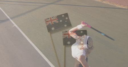 Holding racket athlete practicing serve on outdoor court, with headband and three Australian flags. Athlete, sports, competition, outdoor, activewear, fitness, determinationの写真素材