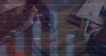 Displaying blue bar charts and purple-red line graphs at workbench, with pen, spool and scissors. Analytics, data visualization, craftsmanship, innovation, professional, productivity, modernの写真素材