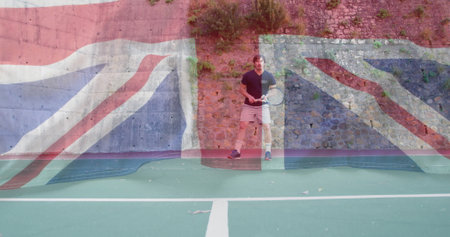 Standing mature male wearing sportswear holding tennis racket on tennis court with stone wall. Athletic, outdoor, sport, active, focused, leisure, trainingの写真素材