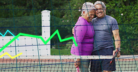 Hugging senior couple in sportswear on tennis court, with rackets and chart overlays, copy space....