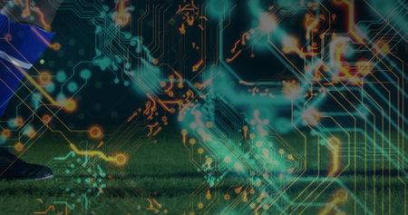 Soccer player leg showing blue sock, black cleat on turf with digital circuitry overlay, copy space....
