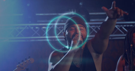 Male vocalist performing on stage, with microphone, metal truss, stage lights, guitar headstock. Concert, performance, stage, music, entertainment, nightlife, lightingの写真素材