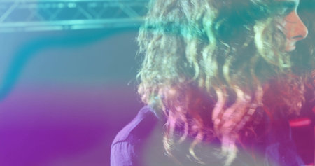 Performing side-profile musician glowing under neon lights on stage, with steel truss, copy space....