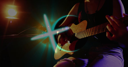 Strumming guitarist in tank top on stage, with acoustic guitar, mic stand, spotlight, blue light....