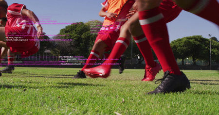 Sprinting soccer players wearing red uniforms, cleats on field at park with orange bib code overlay....