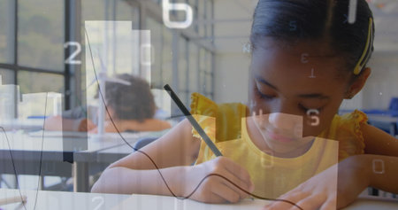 Writing girl wearing yellow top filling paper at school desk by windows, graph overlay, copy space. Students, education, learning, study, classroom, literacy, focusの写真素材