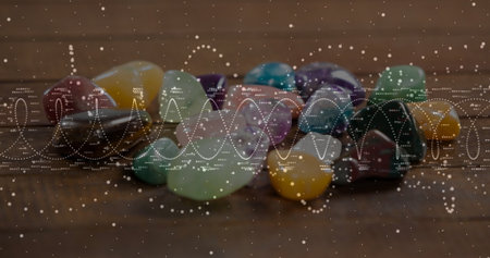 Showcasing polished gemstones sparkling on wooden tabletop in studio, with wave overlay. Gemstones,...