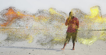 Man in red top olive pants holding smartphone on beach, with swirling particles, copy space. Technology, connectivity, abstraction, serenity, innovation, solitude, digitalartの写真素材