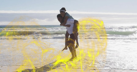 Man giving piggyback ride to woman wearing summer clothes at sandy shore, ocean horizon. Adventure,...