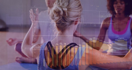 Woman wearing blue sportswear extending arms in yoga studio, with yoga mats and data overlays....