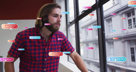 Leaning plaid-shirted man on windowsill gazing out window in office with data tags and search icons....