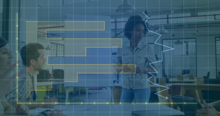 Presenting woman wearing shirt and jeans showing data on whiteboard in office, with laptops....