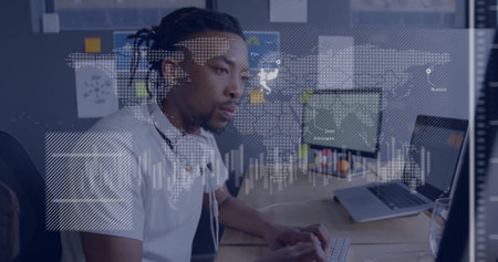 Analyzing digital data overlays by male engineer working at modern office desk, with dual monitors....