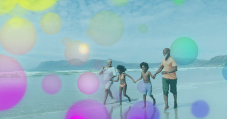 Walking senior adult, parent, children holding hands at shoreline with swimwear and pastel circles....
