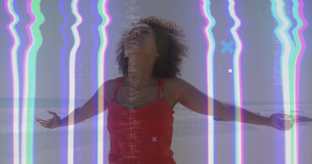 Standing African American woman in red dress arms out tilting head back on beach, glitch overlay....