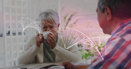 Sipping senior woman and man sharing morning drink on veranda, with mugs smartphone on rustic table....