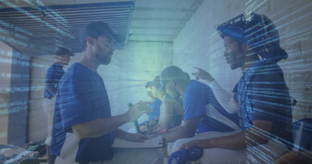 Navy cap coach holding clipboard addressing players in dugout, with bats, code overlay, copy space....