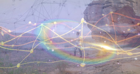 Walking man wearing baseball cap crossing desert toward sandstone outcrop, with network overlay....