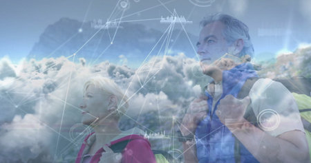 Standing senior couple gazing skyward on mountain ridge, carrying hiking packs with digital overlay....