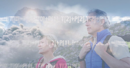 Standing couple gazing toward distant horizon on hillside with jackets, backpacks. Adventure,...