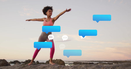 Balancing woman wearing coral sports bra doing yoga on rocky shore at sunset, blue speech bubbles....