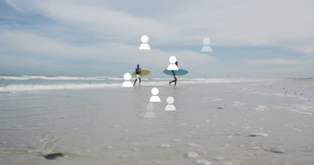 Two men in wetsuits walking through shallow water at beach, carrying lime green and teal surfboards....