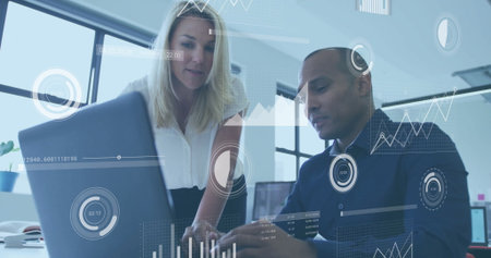 Business colleagues wearing business attire typing on laptop at desk in office, with chart overlays....