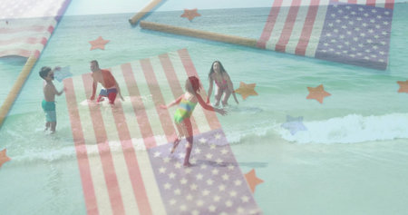 Playing family in swimwear laughing and splashing beach water with American flag and star overlays....