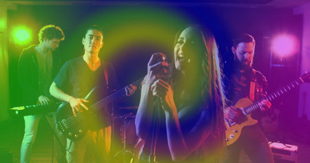 Singing female vocalist gripping mic stand on studio stage, with bass guitar and keyboard....