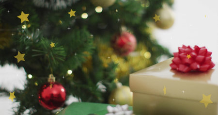 Christmas tree with ornaments and gift boxes over falling stars image. holiday, festive, decorations, presents, celebration, winterの写真素材