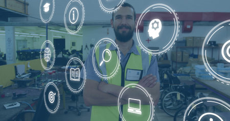 Surveying warehouse worker wearing safety vest crossing arms in workshop, with digital icons....