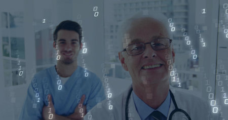 Smiling senior doctor wearing white coat in hospital corridor, with nurse in scrubs, binary overlay. Healthcare, professionalism, medical, digital, technology, teamwork, clinicalの写真素材